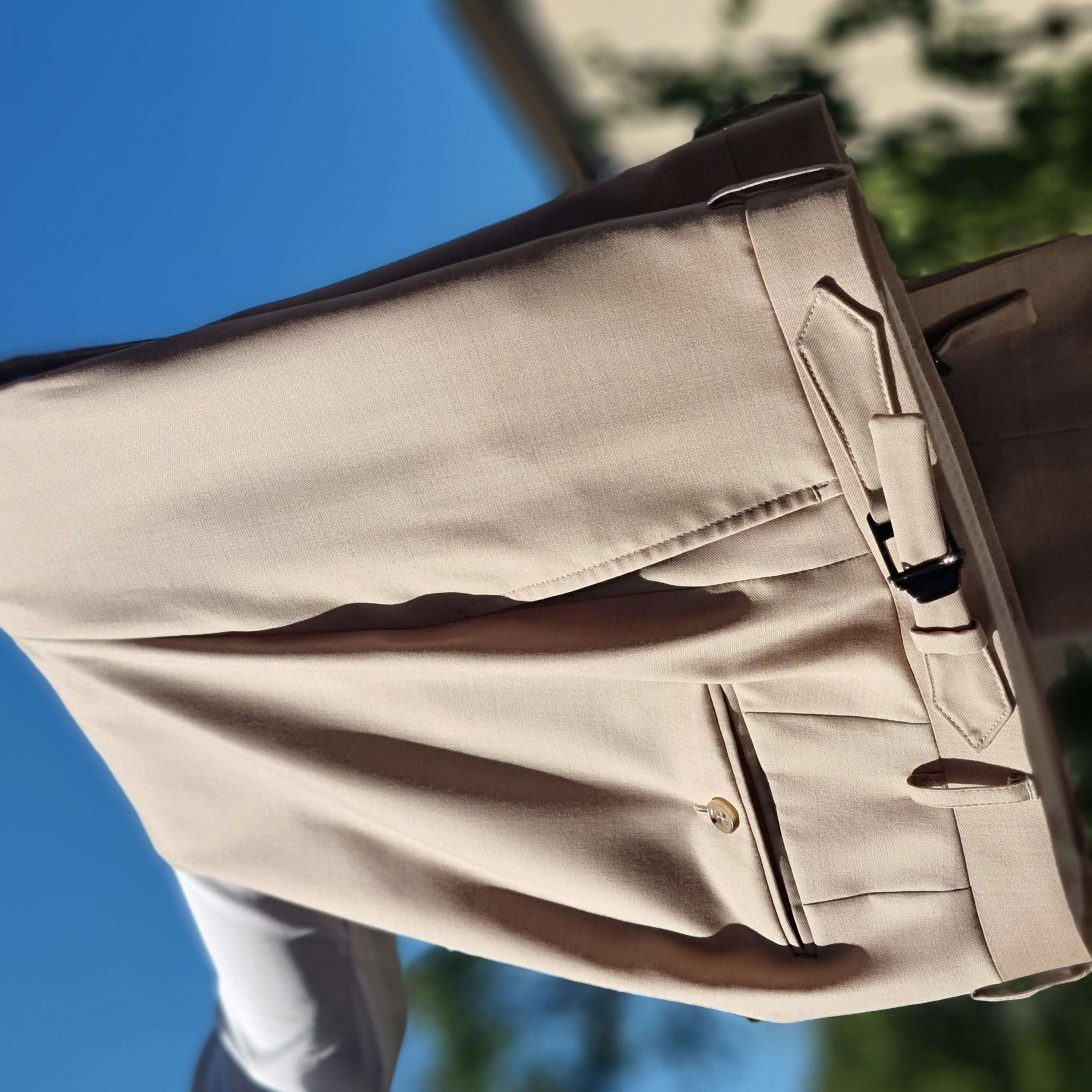 Beige Masshose mit Bundfalten, Seitentaschen und Bundweitenregler im Detail