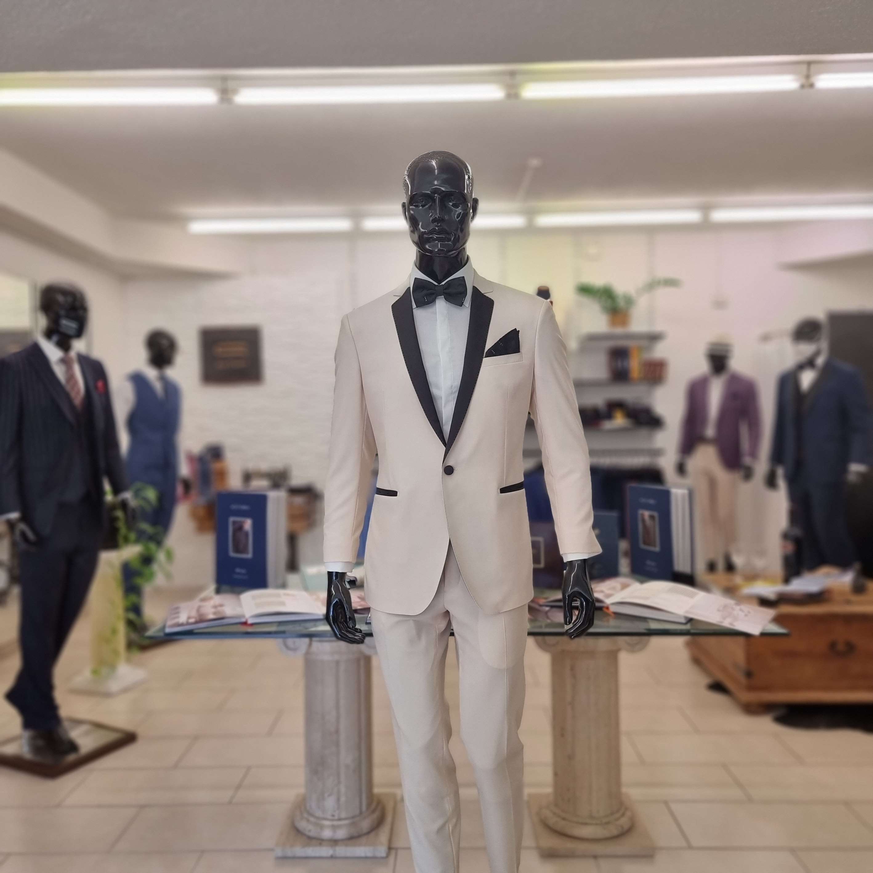 Mannequin in an ivory dinner jacket with black lapels and bow tie in the SuitArt shop