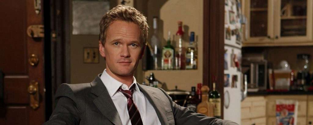 Barney Stinson aus «How I Met Your Mother» im grauen Anzug mit weissem Hemd und rot gestreifter Krawatte